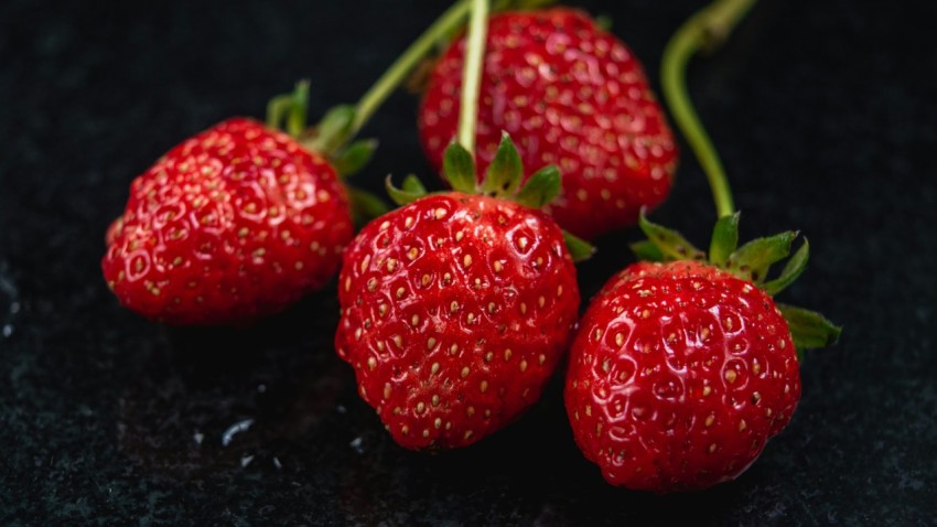 a group of three strawberries sitting on top of a table