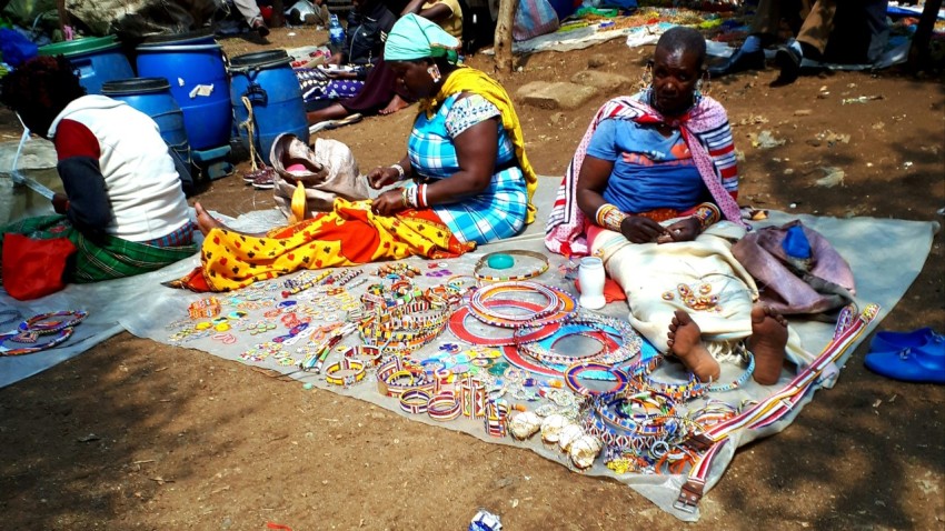 people sitting on white textile beside beaded decors