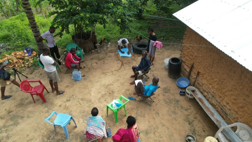 a group of people standing around a small house nV0bPRK