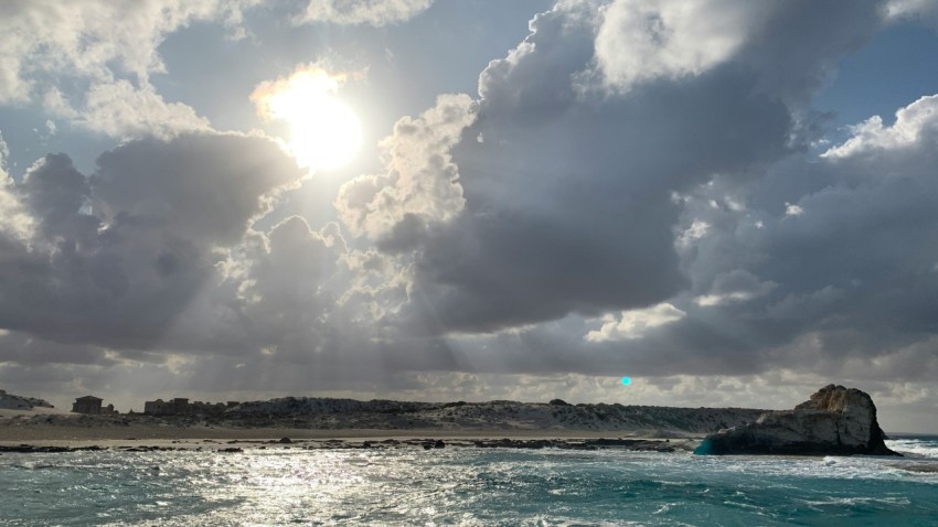 the sun is shining through the clouds over the ocean