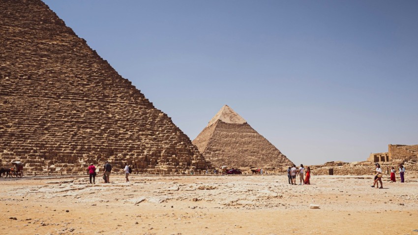 a group of people standing in front of a group of pyramids