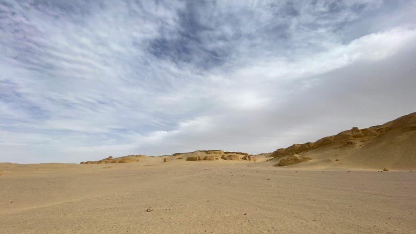 a desert with sand dunes and clouds in the sky vtImX53L