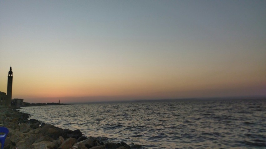 a view of a body of water with a clock tower in the distance