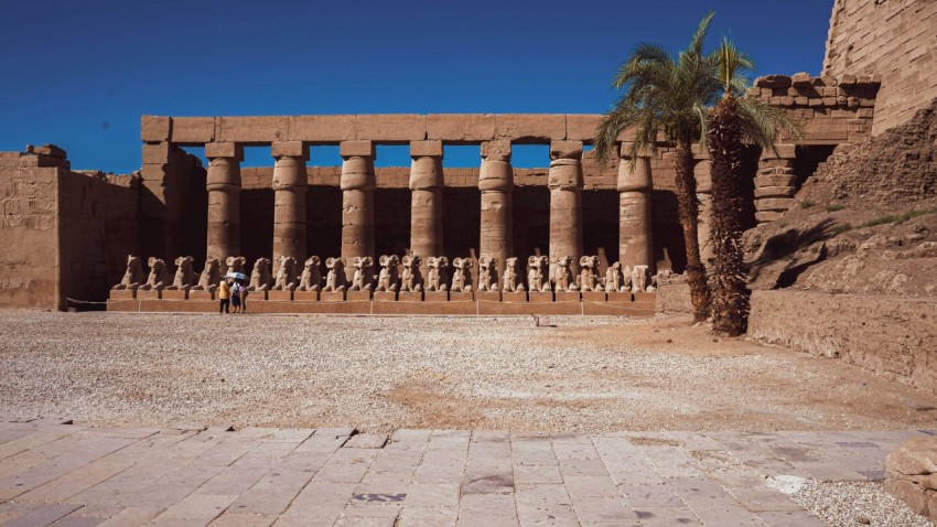 a group of people standing in front of a building with columns