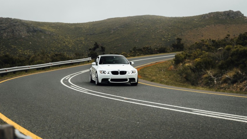 a white car driving down a curvy road