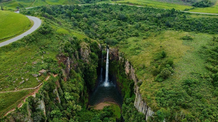 a large waterfall in the middle of a lush green valley