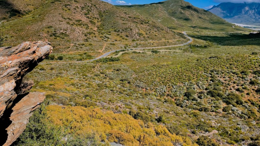 a scenic view of a winding road in the mountains