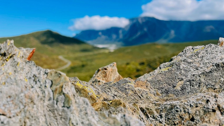 a close up of rocks with mountains in the background