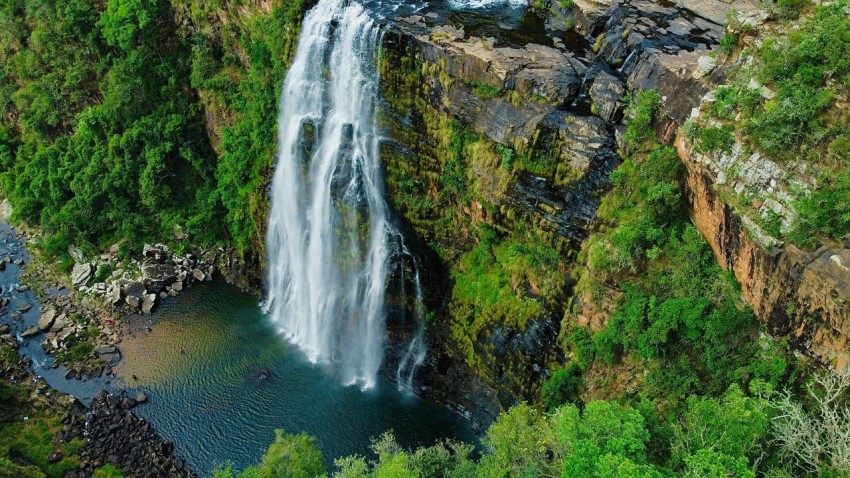 a waterfall in the middle of a lush green forest