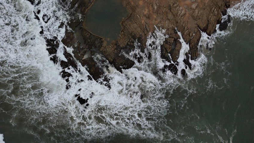 a birds eye view of the ocean and rocks