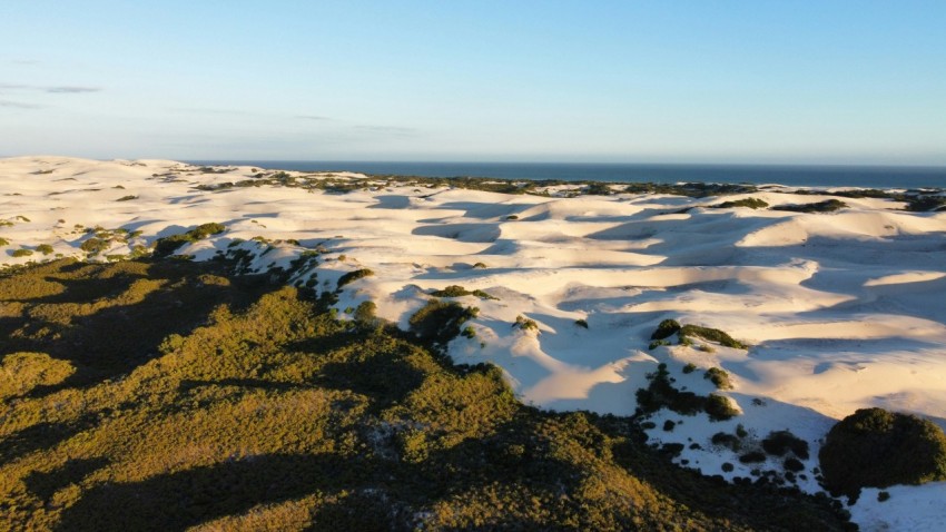 a snow covered hill with a body of water in the distance Oux T