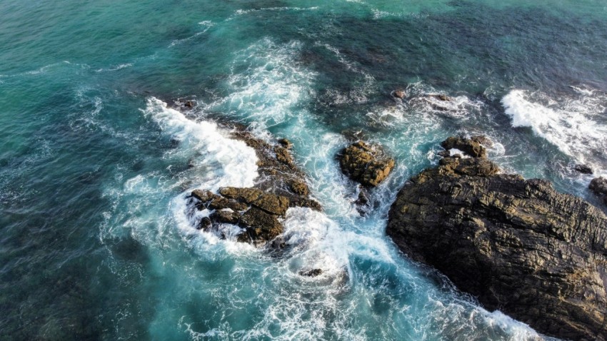 brown rock formation on body of water during daytime