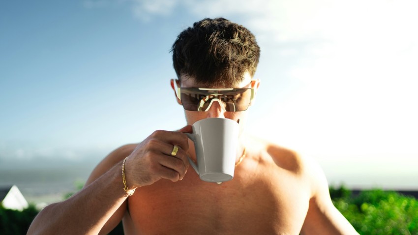 a shirtless man holding a coffee cup up to his face _PLTH