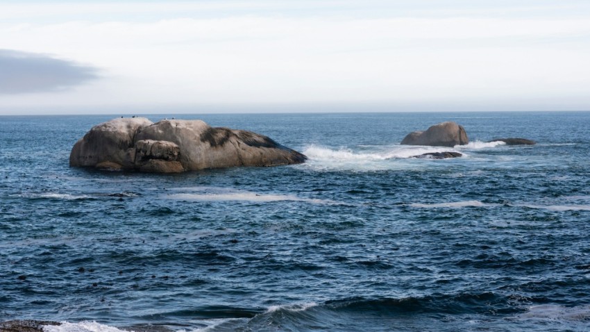 a large rock in the middle of the ocean