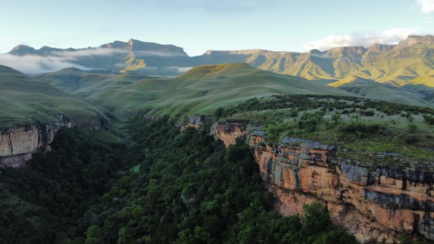 a scenic view of a valley with mountains in the background
