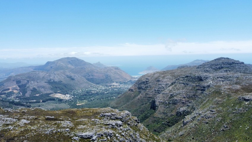 a couple of mountains with a body of water in the distance