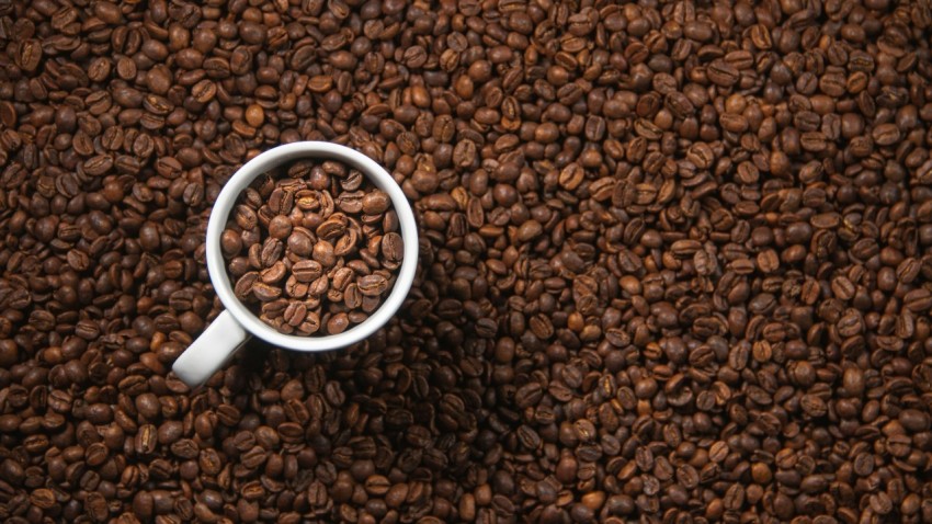 white ceramic mug on brown coffee beans