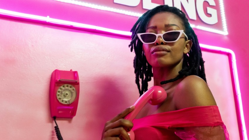 a woman in a pink dress holding a pink phone