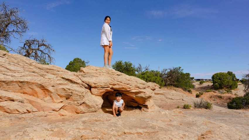 a woman standing on top of a large rock