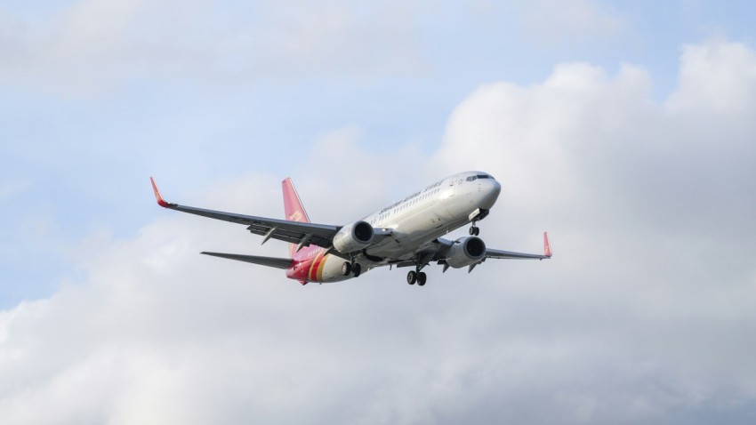a large jetliner flying through a cloudy blue sky