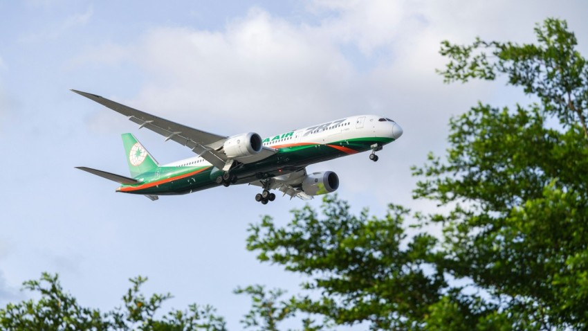 a large jetliner flying through a cloudy blue sky