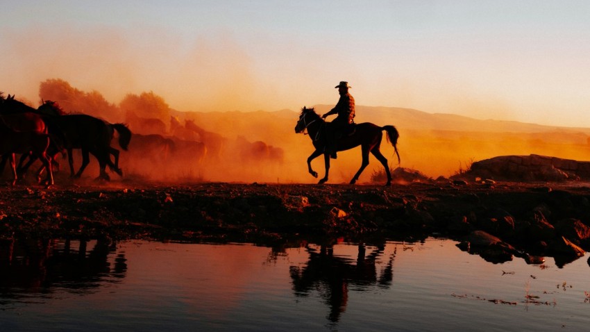a group of people riding horses across a river cymbGJ
