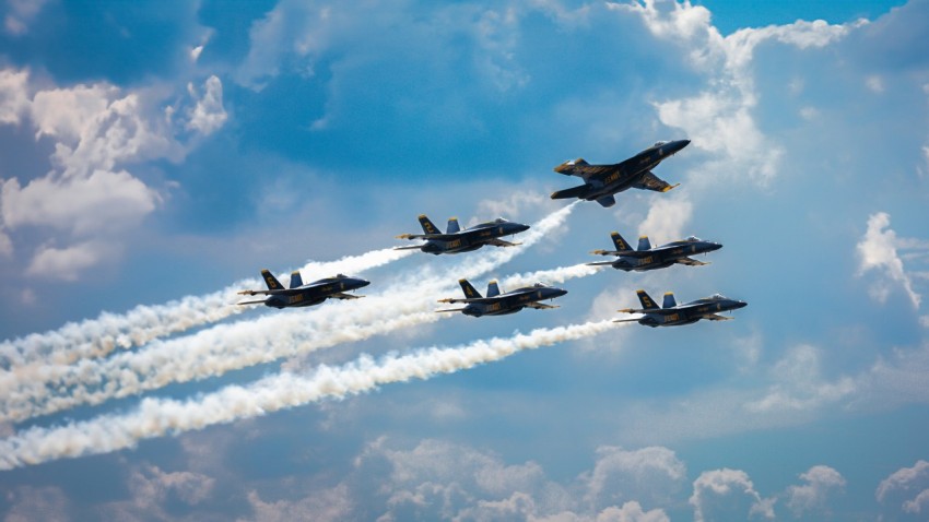 a group of fighter jets flying through a cloudy sky