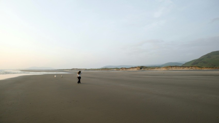 a person standing on a beach next to the ocean bJBEi