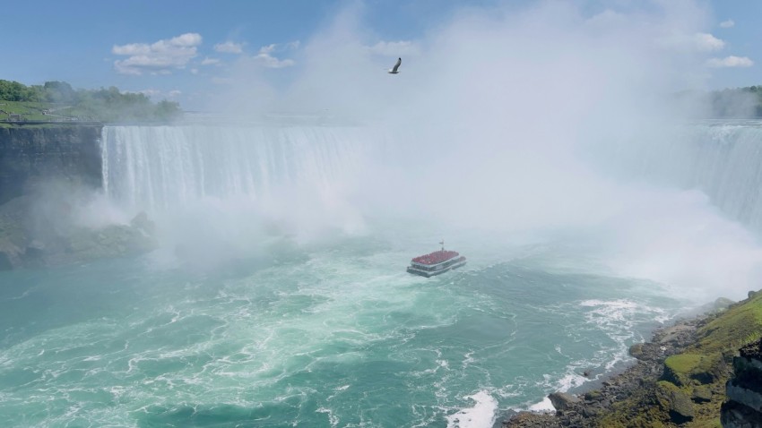 a boat is in the water near a waterfall