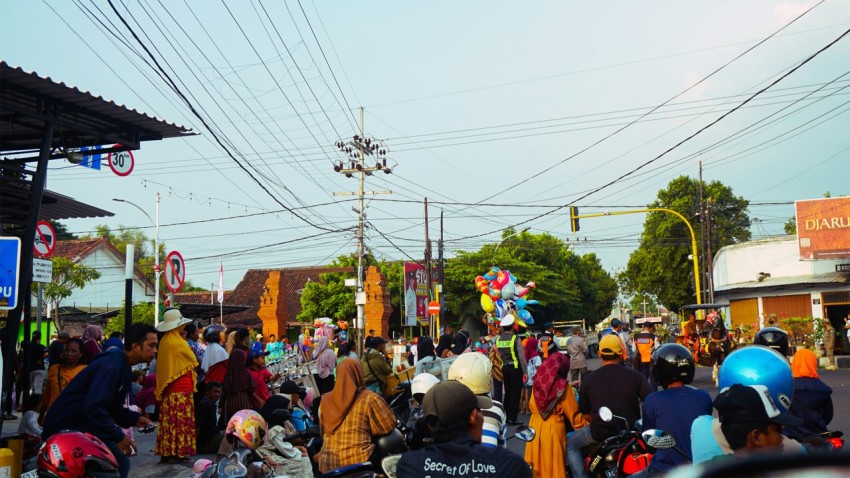 a group of people riding motorcycles down a street