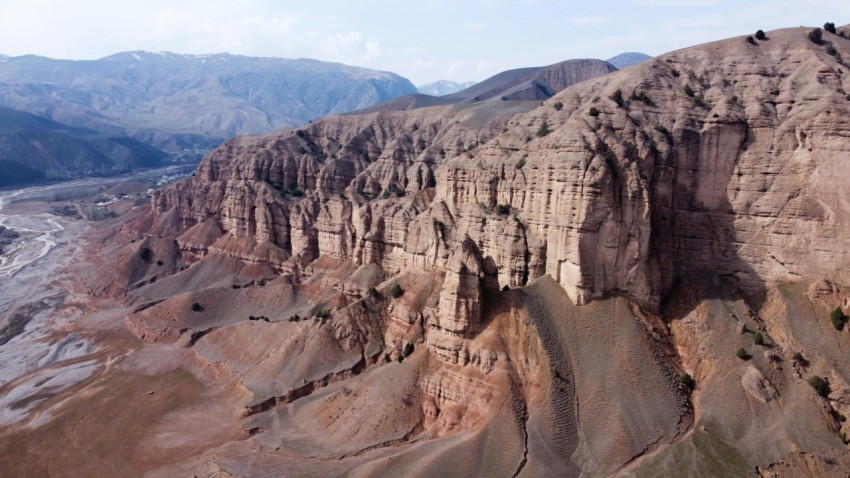 an aerial view of a mountain range with mountains in the background