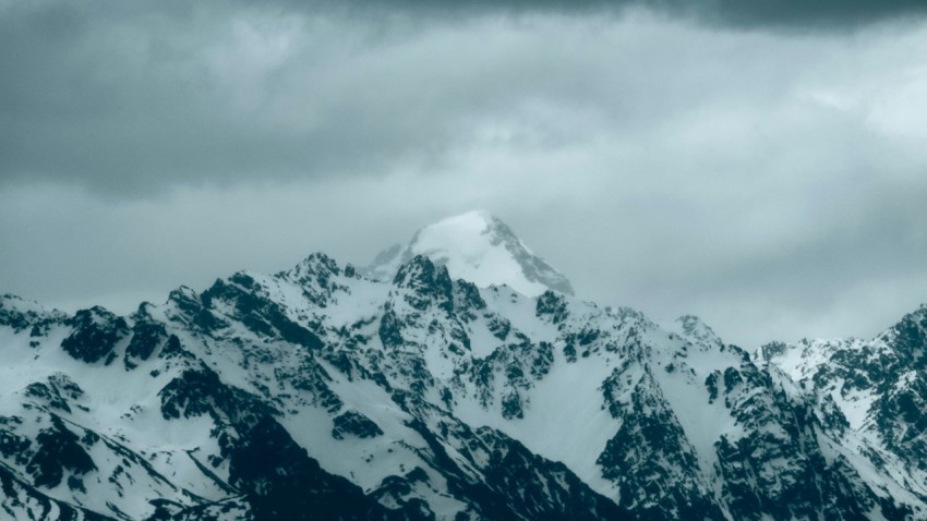 a snowy mountain with clouds