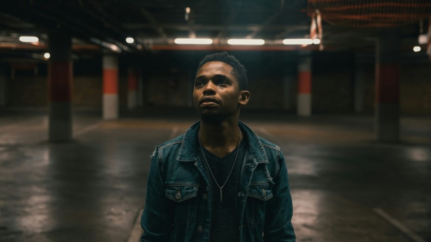 man standing wearing blue denim button up jacket inside building