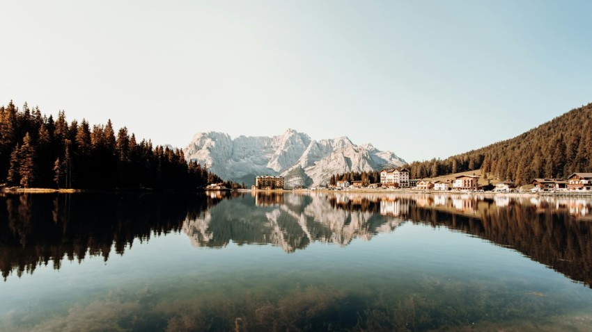 body of water near trees and mountain during daytime