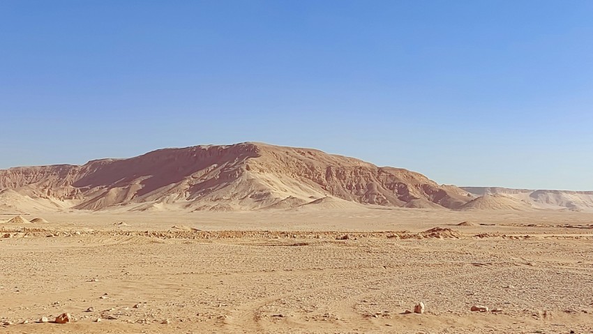 a desert landscape with a mountain in the background y30IUND