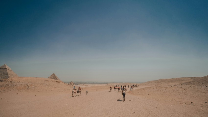 a group of people walking across a sandy field 2 wt