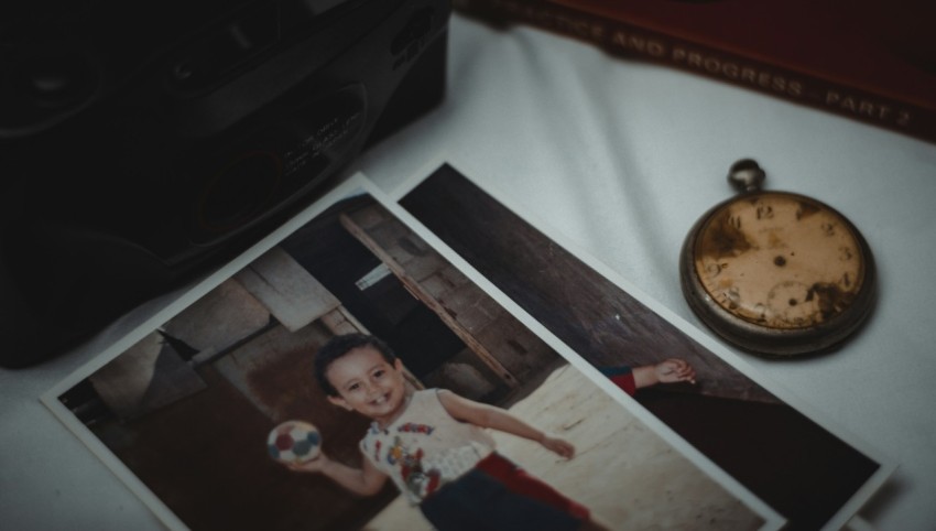 a photo of a young boy next to a pocket watch