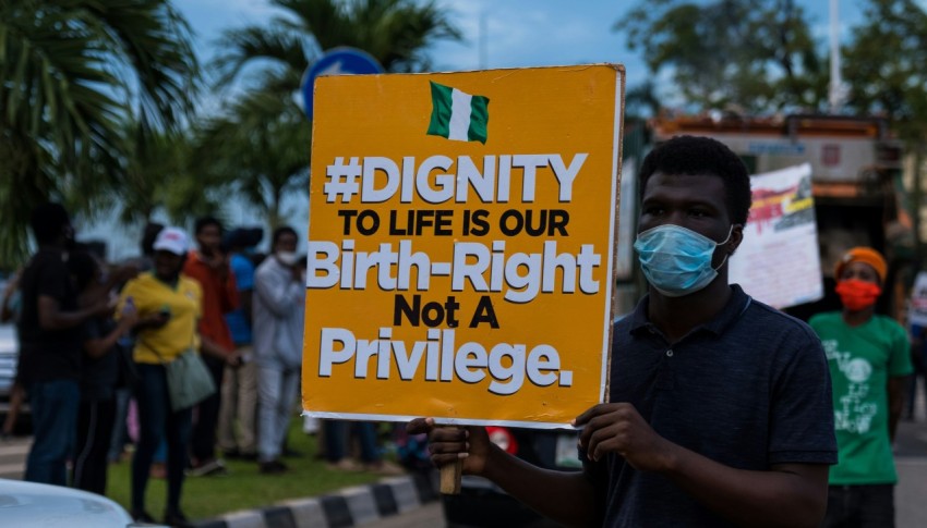 a man holding a sign that says dignity to life is our birth