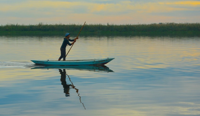 a man on a small boat in the water