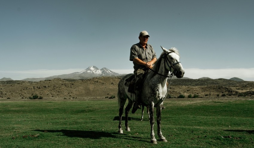 a man riding on the back of a black and white horse