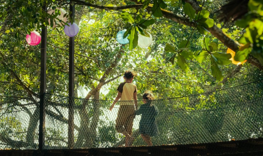 a woman and a child walking across a bridge 5Vc