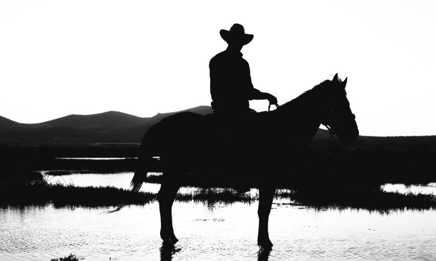 a man riding a horse near a body of water