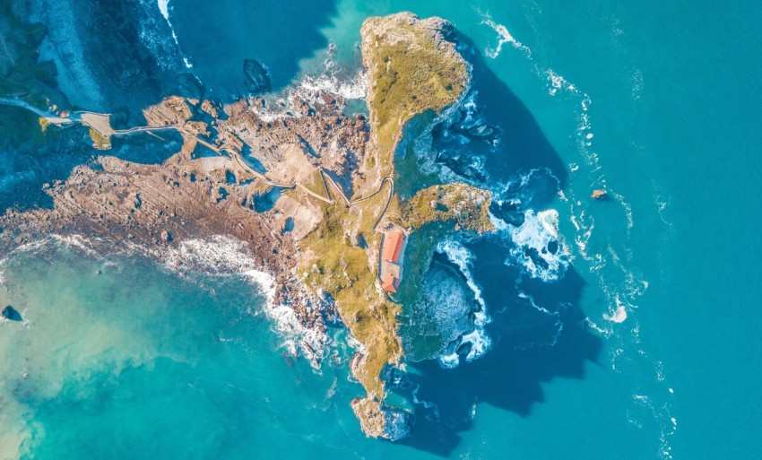 birds eye view photo of sea waves crushing on boulders