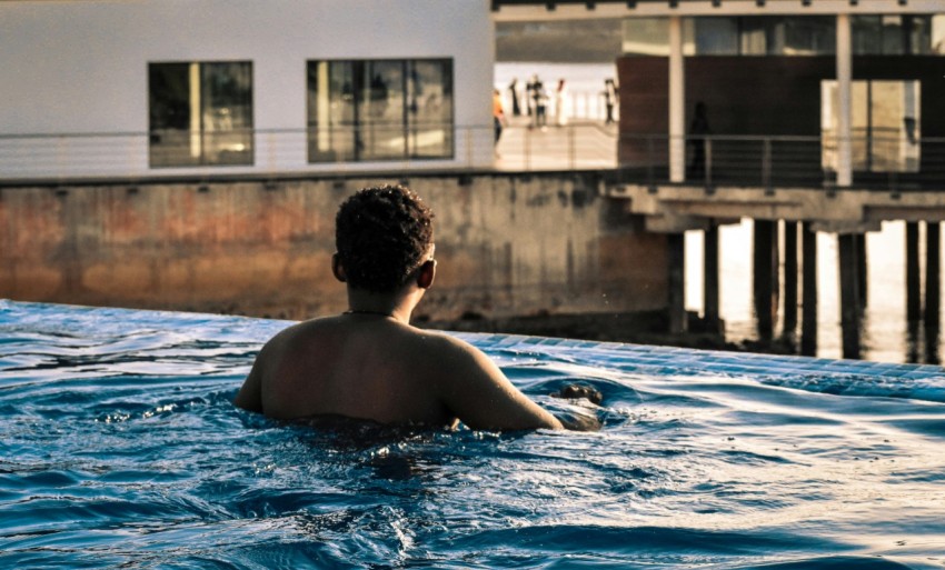 topless man swimming on pool