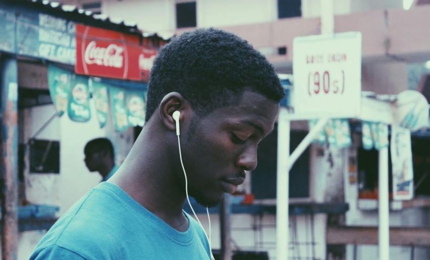 man wearing blue crew neck shirt wearing earbuds