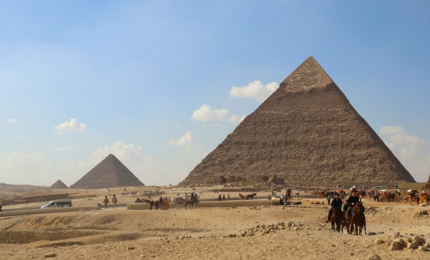 a group of people riding horses in front of a pyramid rlQGp4b