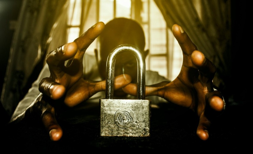 a person holding a padlock in front of a window