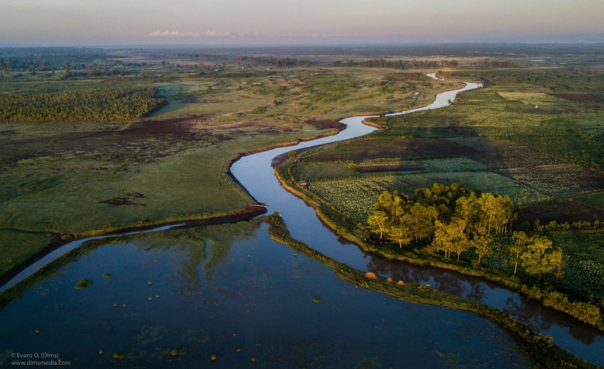 a river running through a lush green countryside