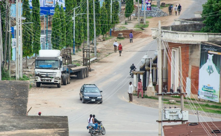 a truck driving down a street next to a couple of people Jwp7OiYR_