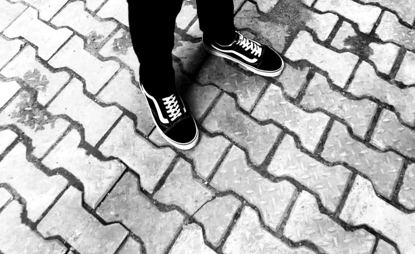 person in black pants and black vans low top sneakers qOKvl1WxR